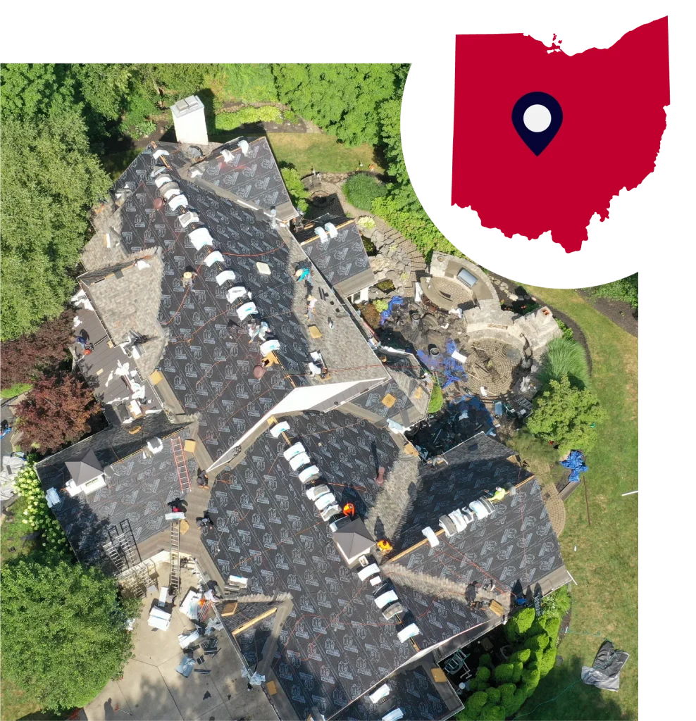 Aerial view of roofing crew installing shingles on a large residential roof.